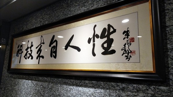 圖四 : 佐臻門口擺了「科技來自人性」的書法，這也是梁文隆給自己的目標。（攝影／籃貫銘）