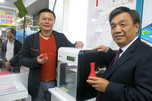 XYZprinting董事长沈轼荣(左)展示自家XYZPrinting。(图/陈韦哲摄)