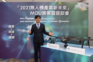 经济部展示抗七级风雨无人机,可在恶劣环境下作业。图为经济部技术处处长邱求慧与无人机合影。