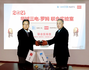 华域三电总经理王骏(右)与ROHM半导体(上海)有限公司董事长藤村 雷太(左)在启用仪式上互赠纪念品